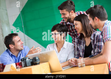 Unternehmer im Gespräch mit jungen Menschen in Coffee-shop Stockfoto