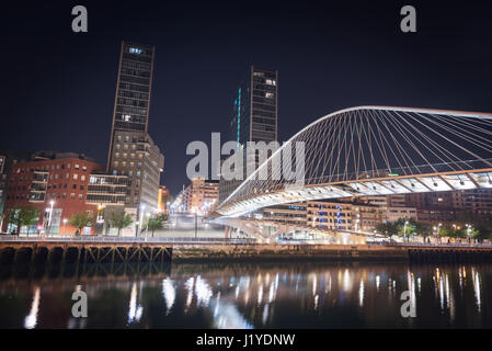 Stadtbild Bilbao und Fußgänger Zubizuri Brücke bei Nacht, Bilbao, Baskenland, Spanien. Stockfoto