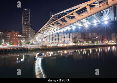 Stadtbild Bilbao und Fußgänger Zubizuri Brücke bei Nacht, Bilbao, Baskenland, Spanien. Stockfoto