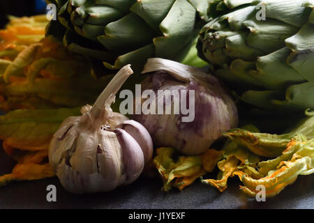 Gemischtes Gemüse mit Knoblauch und Artischocken in körnigen stimmungsvolle Beleuchtung Stockfoto