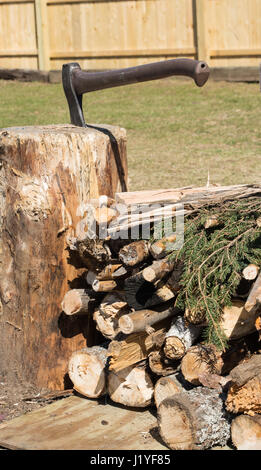 Stapel von Lagerfeuer Holz mit einer Axt in einen Baumstumpf. Stockfoto