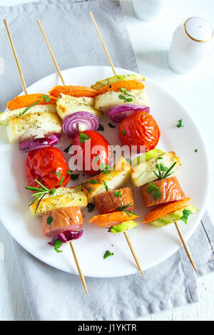 Gegrillte Wurst und Gemüse-Spieße mit frischen Kräutern auf weißen Teller Stockfoto