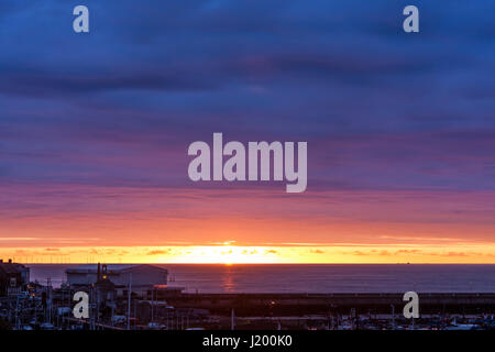 England, Ramsgate Hafen. Sonnenaufgang über dem Ärmelkanal. Vordergrund Ramsgate Hafen. Kleine band der offenen orange Himmel mit Sonne, über dass dicke Schichten mauve Cloud. Stockfoto