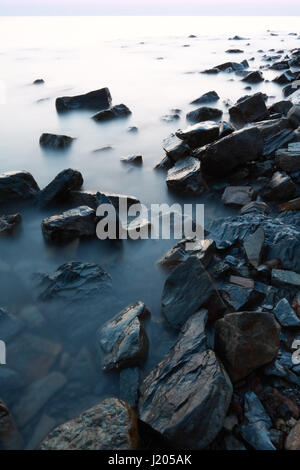 Eine Landschaft der Küste des Schwarzen Meeres mit massiven Steinen und ruhige Wasseroberfläche in der Abenddämmerung Stockfoto