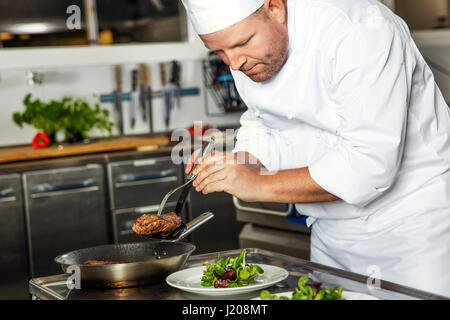 Fokussierte Chefkoch Steak Teller im Gourmet-restaurant Stockfoto
