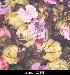 Blumenkarte Matte. Gelbe Rosen und rosa Nelken mit lila Laub. Retro-Stil-Verarbeitung. Stockfoto