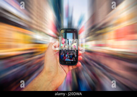 New York Zeit Squatre mit dem Smartphone Abend fotografieren. Blured Hintergrund Stockfoto