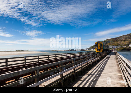 Zug der Brücke Mawddach Mündung Eisenbahn auf die Cambran Küste in der Nähe von Barmouth, Gwynedd, Wales Stockfoto