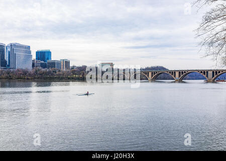 Washington DC, USA - 20. März 2017: Frau Rudern auf Boot am Potomac River mit Skyline oder Stadtbild von Arlington in Virginia Stockfoto