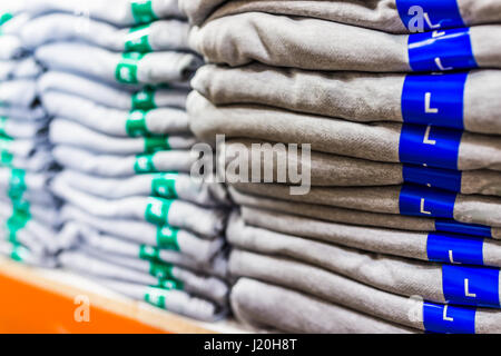 Große und extra große t-Shirts zum Verkauf auf dem Display im Store gestapelt Stockfoto