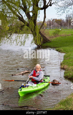 Detroit, Michigan - holt ein Freiwilliger in einem Kajak Papierkorb im Frühjahr die Säuberung von Belle Isle, ein State Park auf einer Insel im Detroit River. Stockfoto