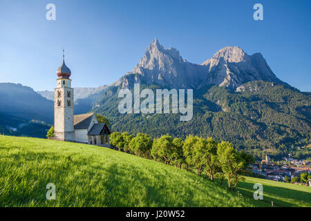 Panoramablick auf der idyllischen Berglandschaft der Dolomiten mit St. Valentin Kirche und berühmten Mount Schlern im schönen Morgenlicht bei Sonnenaufgang Stockfoto