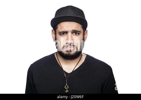 Porträt des jungen traurig unglücklich Mann mit schwarzen T-shirt und Cap Blick in die Kamera. Studioaufnahme, isoliert auf weißem Hintergrund. Stockfoto