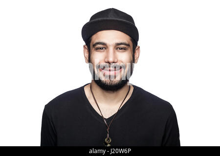 Porträt des jungen glücklich smilely Mann mit schwarzen T-shirt und Mütze mit toothy Lächeln in die Kamera schauen. Studioaufnahme, isoliert auf weißem Hintergrund. Stockfoto