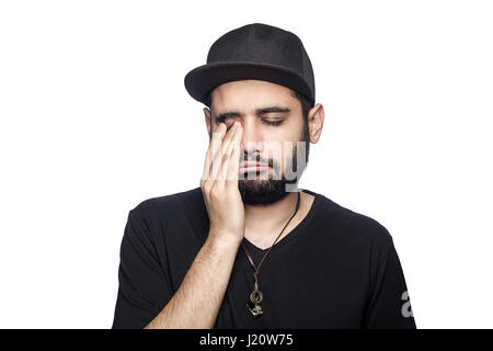 Porträt des jungen unglücklich trauriger Mann mit schwarzen T-shirt und Cap Blick auf Kamera Weinen schloss die Augen. Studioaufnahme, isoliert auf weißem Hintergrund. Stockfoto