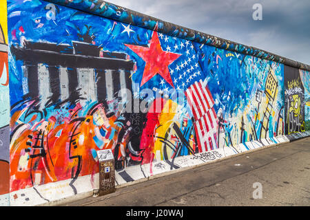 Panoramablick auf der berühmten Berliner Mauer dekoriert mit bunten Graffiti Streetart in historischen East Side Gallery auf einem stimmungsvollen bewölkten Tag im Sommer, Berlin Stockfoto