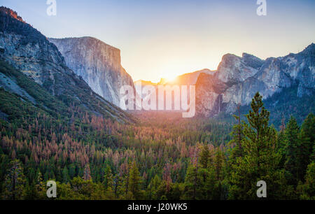 Tunnel-Standardansicht des malerischen Yosemite Valley mit berühmten El Capitan und Half Dome Klettern Gipfeln im schönen goldenen Morgenlicht bei Sonnenaufgang Stockfoto