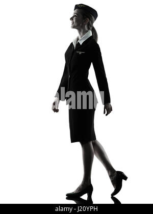eine kaukasische Stewardess Kabine Crew Frau zu Fuß isolierten auf weißen Hintergrund in der silhouette Stockfoto