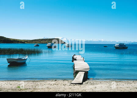 Isla del Sol, Titicacasee, Bolivien. Pier und Boote mit den Anden im Hintergrund. Stockfoto