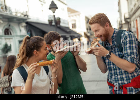 Glückliche Gruppe von Freunden Essen Pizza im freien Stockfoto