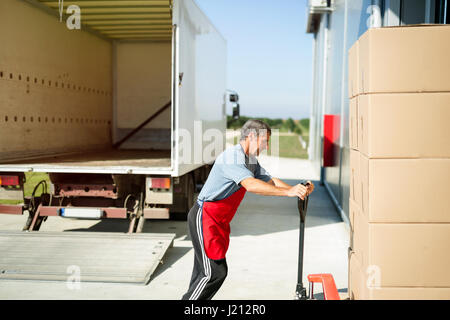 Logistik-Arbeiter tragen gelieferte Ware ins Lager Stockfoto