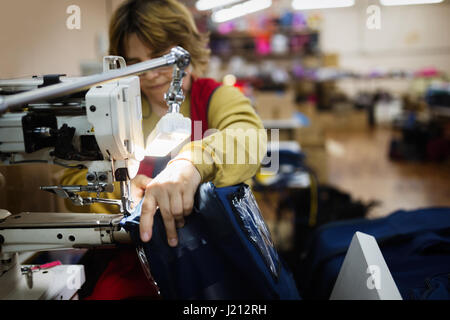 Frau arbeitet in der nähenden Industrie auf Maschine Stockfoto