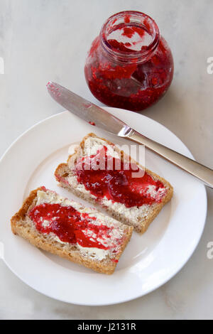 Himbeermarmelade auf Vollkorn Toast. Stockfoto