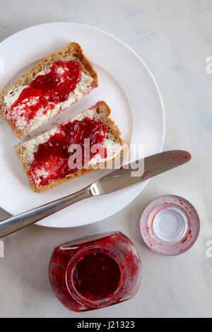 Himbeermarmelade auf Vollkorn Toast. Stockfoto