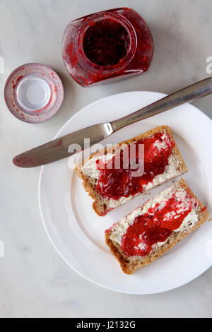 Himbeermarmelade auf Vollkorn Toast. Stockfoto