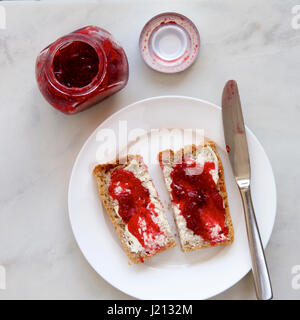 Himbeermarmelade auf Vollkorn Toast. Stockfoto