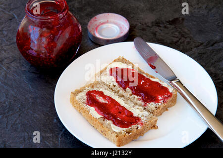 Himbeermarmelade auf Vollkorn Toast. Stockfoto