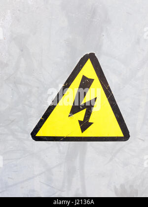 ein Warnschild gelb und schwarz auf silbernem Metall Hintergrund elektrische Bolzen im Dreieck Sicherheit Vorsicht Vorsicht Gefahr Strom Tod Stockfoto