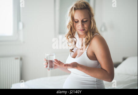 Schöne schwangere Frau, die Einnahme von Pillen für morgen Übelkeit Stockfoto