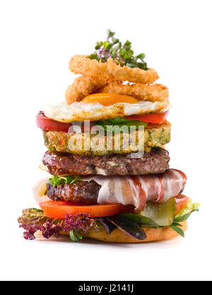 Big Burger mit Speck, Frikadellen, Spiegelei, Zwiebeln, Tomaten, eingelegte Gurken und Salat. Isoliert auf weißem Hintergrund. Stockfoto