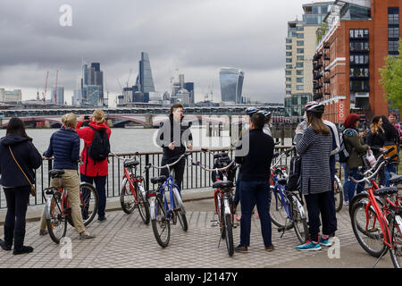 Touristen auf einer Radtour entlang dem Südufer der Themse in London Stockfoto