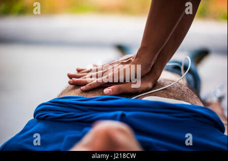 ein Mädchen hilft einen Kerl nach dem Herzinfarkt mit Reanimation Stockfoto