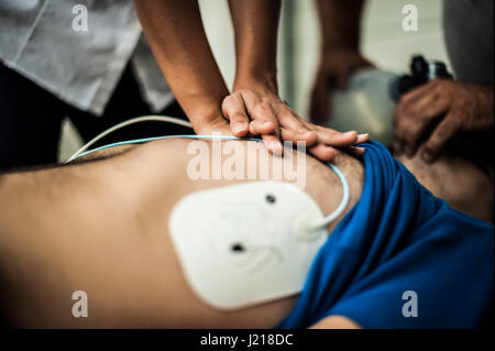 ein Mädchen hilft einen Kerl nach dem Herzinfarkt mit Reanimation Stockfoto