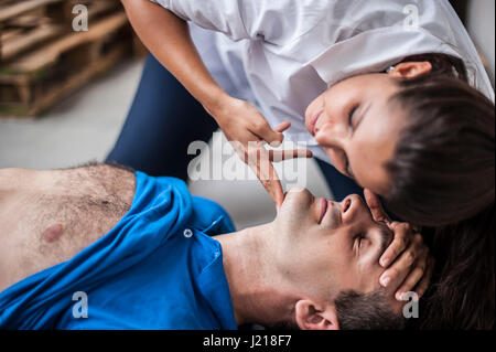 ein Mädchen hilft einen Kerl nach dem Herzinfarkt mit Reanimation Stockfoto