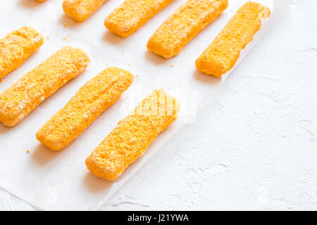 Gefrorene Fischstäbchen, Fischstäbchen auf Papier und weißem Hintergrund kopieren Sie Raum. Convenience-Food, Meeresfrüchte, Fischstäbchen Essen Stöcke. Stockfoto