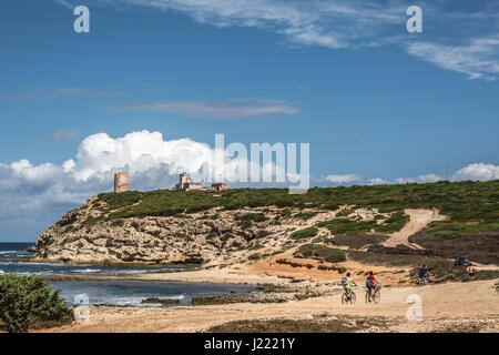 Capo Mannu Cliffs mit blauem Himmel, dramatische Wolken und einige Radfahrer. In Capo Mannu Strand, Sardinien, Italien am 10. August 2015 geschossen. Stockfoto