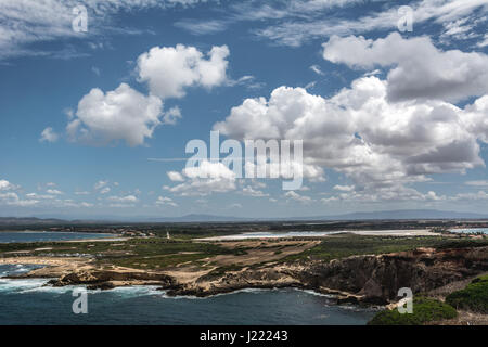 Capo Mannu Cliffs und Strand gegen blaue Meer oder Ozean mit blauen Himmel und Cumulus-Wolken. Schuss in Capo Mannu, Mesa Longa Strand, Sardinien, Italien. Stockfoto