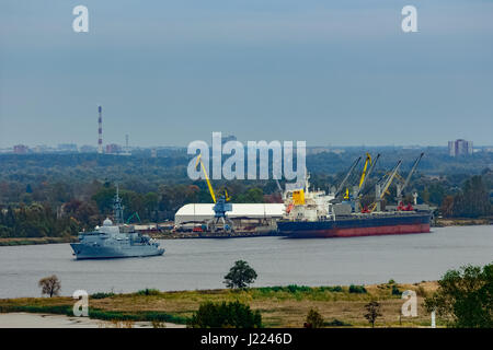 Militärisches Schiff Segeln vorbei an den Frachthafen in Riga, Lettland Stockfoto