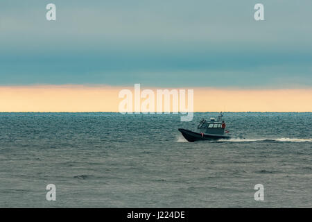 Kleine graue Grenze Wache Boot bewegt sich schnell in die noch am Abend Stockfoto