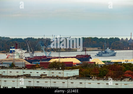 Militärisches Schiff Segeln vorbei an den Frachthafen in Riga, Lettland Stockfoto