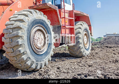 Nahaufnahme der roten Lader Fahrwerk Schritte auf der Seite-Baustelle. Stockfoto