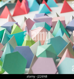 Bunte abstrakte geometrische Hintergrund mit dreidimensionalen solide Zahlen. Pyramide Dodekaeder Prisma rechteckigen Würfel angeordnet auf weißem Papier. Stockfoto