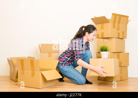 Frau, ein- und Auspacken der Sachen in einen Karton beim Hause bewegen. asiatische chinesische Modell Mischlinge Stockfoto