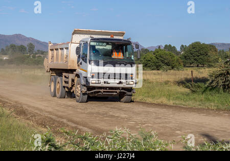 Baustellen-Lkw bewegt sich schnell mit Last von Fels und Sand auf ländlichen Feldweg White - fotografieren Stockfoto