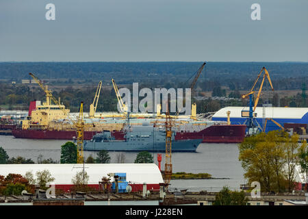 Militärisches Schiff Segeln vorbei an den Frachthafen in Riga, Lettland Stockfoto