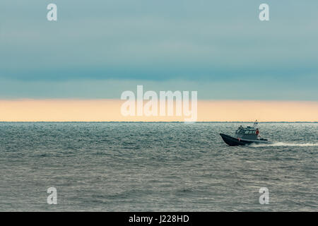 Kleine graue Grenze Wache Boot bewegt sich schnell in die noch am Abend Stockfoto